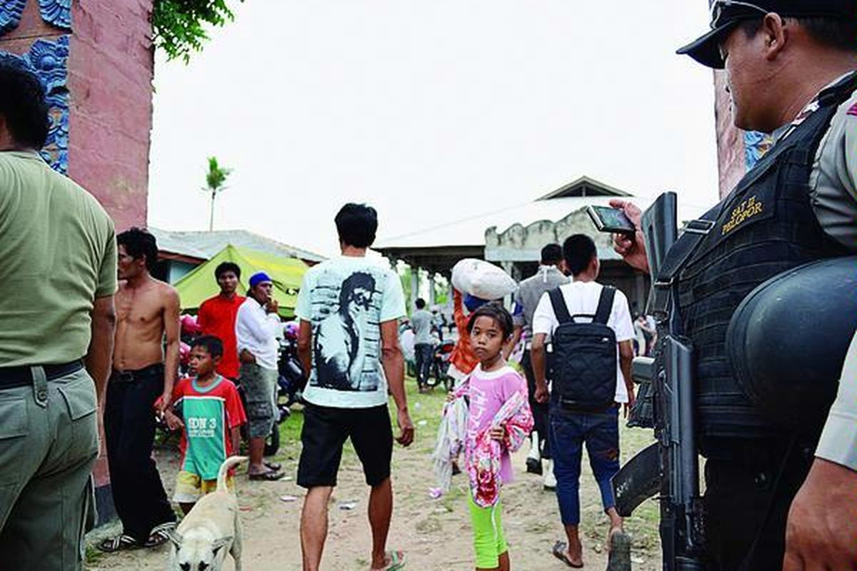 Polisi mengawal warga Desa Balinuraga, Kecamatan Way Panji, Kabupaten Lampung Selatan, Provinsi Lampung, pulang ke tempat tinggal mereka, Senin (5/11). Mereka meninggalkan pengungsian di Sekolah Kepolisian Negara di Kemiling, Bandar Lampung, setelah kesepakatan damai pihak bertikai.