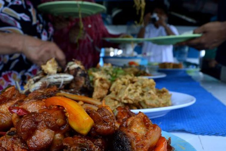 Para wisatawan asal India sedang bersiap mengambil makanan untuk santap siang di atas kapal setelah mengunjungi Pulau Komodo, Kecamatan Komodo, Manggarai Barat, Nusa Tenggara Timur, Kamis (19/11/2015).