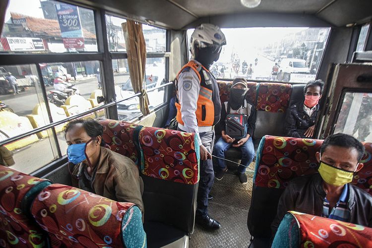 Petugas Dishub mengecek jarak duduk penumpang di dalam bus kota pada penerapan Pembatasan Sosial Berskala Besar (PSBB) di Cibinong, Kabupaten Bogor,  Jawa Barat, Rabu (15/4/2020).Pemerintah telah resmi menerapkan Pembatasan Sosial Berskala Besar (PSBB) di wilayah Bogor, Depok, dan Bekasi per hari ini dalam rangka percepatan penanganan COVID-19.