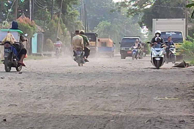 Sejumlah warga melintasi jalan rusak di kawasan Jalan Raya Nyimas Cangkring, Kecamatan Plered, Kabupaten Cirebon, Jawa Barat, Selasa (9/5/2023) pagi.