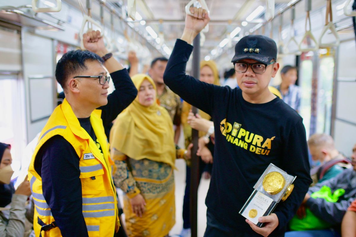 Wali Kota Bogor Bima Arya Sugiarto saat membawa Piala Adipura sambil menaiki kereta commuter line (KRL) dari Stasiun Kalibata menuju Stasiun Bogor, Selasa (5/3/2024).
