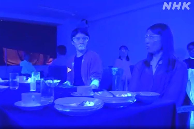 Video hasil eksperimen NHK menunjukkan, virus corona menyebar sangat cepat di restoran. Terlihat dari banyaknya cat neon yang tersebar di berbagai benda bahkan wajah pengunjung. Cat itu mewakili patogen Covid-19.