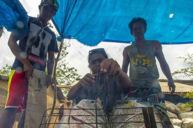 Bakar ikan di Pantai Pink, Kabupaten Lombok Timur, Nusa Tenggara Barat.