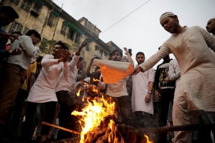 Para demonstran membakar foto Perdana Menteri India Narendra di Kolkata sebagai protes atas pengesahan UU Kewarganegaraan yang kontroversial karena dianggap anti-Muslim.