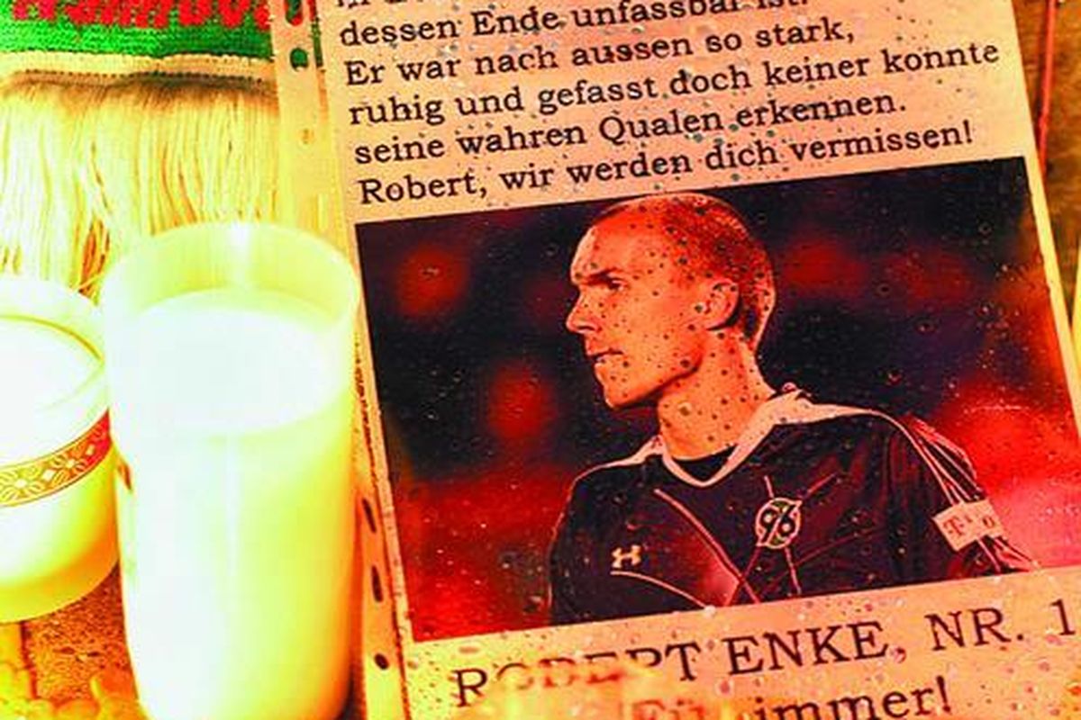 Suporter menyalakan lilin di sisi gambar Robert Enke sebagai penghormatan terakhir kepada Enke yang tewas dengan cara bunuh diri di Hanover, Jerman, Selasa (10/11).
