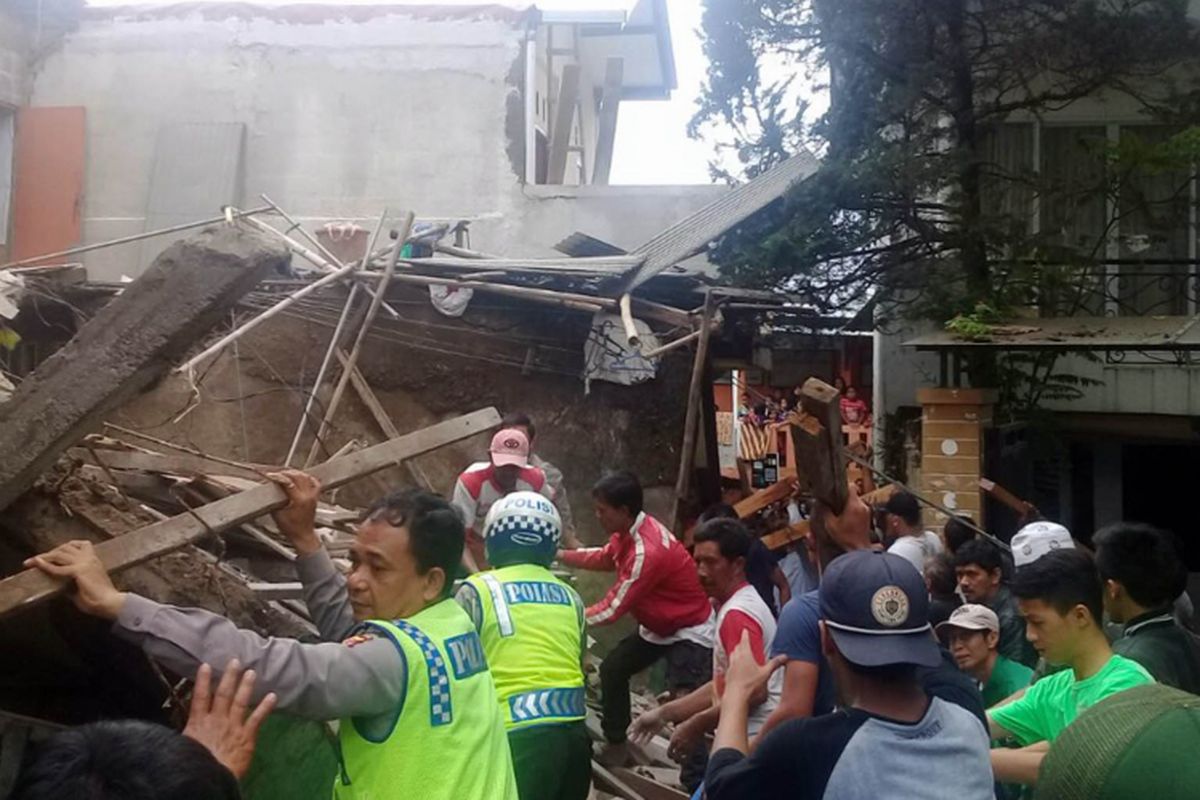 Petugas kepolisian dan warga sekitar sedang melakukan proses evakuasi terhadap korban rumah ambruk di Desa Cisarua, Kecamatan Cisarua, Puncak, Bogor, Jawa Barat,  Sabtu (18/3/2017).