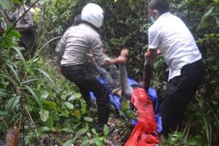 Pria tanpa identitas yang diduga menjadi korban pembunuhan sedang dievakuasi polisi disebuah kebun karet di Kelurahan Sanggau Kulur, Singkawang, Kalimantan Barat (6/11/2013)