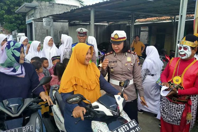 Kasatlantas Polres Demak, AKP Nyi Ayu Fitria Facha atau Yu Es Teh memberikan edukasi tertib berlalu lintas kepada emak - emak, saat studi kasus dengan menggelar simulasi operasi simpatik di Jalan Desa Karangsari Kecamatan Karangtengah Kabupaten Demak, Rabu (11/3/2020)