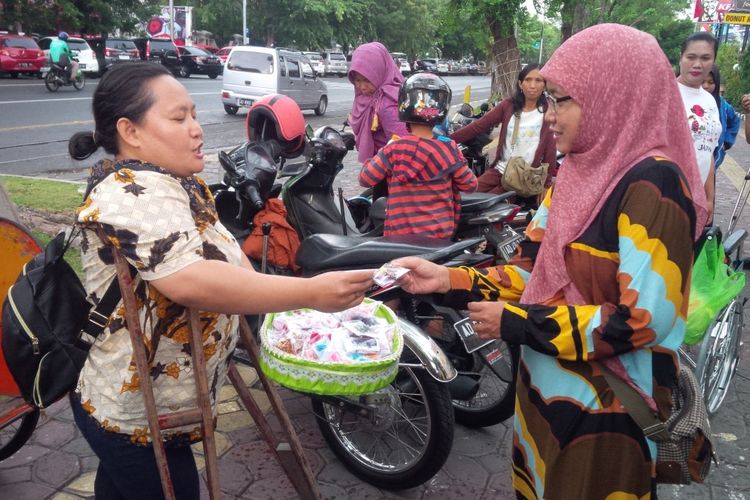 Penyandang disabilitas tergabung Self Help Group (SHG) Solo membagikan suvenir berupa bros kepada masyarakat di jalur lambat Jalan Slamet Riyadi depan Solo Grand Mal Solo, Jawa Tengah, Senin (3/12/2018).