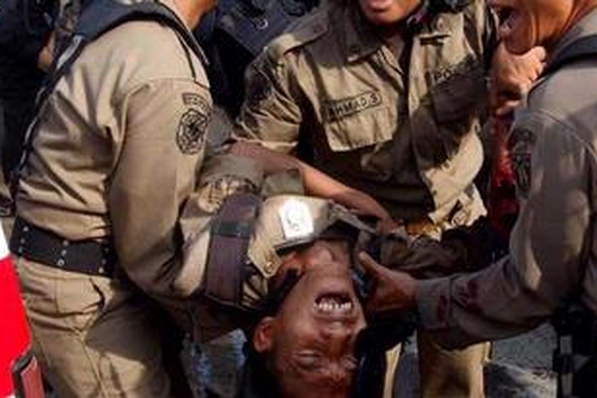 Anggota Satpol PP terluka akibat sabetan senjata tajam saat upaya pembongkaran kompleks makam Mbah Priuk di Tanjung Priok, Jakarta, Rabu (14/4/2010). Sedikitnya empat orang anggota satpol pp terluka saat bentrokan dengan warga terjadi. 