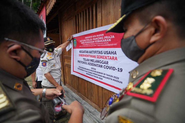 TUTUP—Petugas Satpol dan Damkar Kota Madiun menutup sementara The Forest Cafe yang berdiri dilahan Pusdikbang SDM Perhutani Madiun lantaran melanggar protokol kesehatan di masa PPKM dengan menerima pengunjung melebihi 25 persen dari kapasitas tempat duduk, Rabu (27/1/2021).