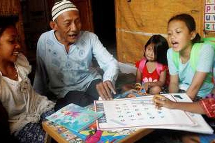 Ratemat Aboe (77) belajar bersama anak didiknya di Rumah Belajar Kakek Aboe, Minggu (24/7/2016). Ratemat Aboe, tukang becak, menjadikan rumah petak kontrakannya menjadi rumah bimbingan belajar gratis bagi anak-anak kurang mampu di kampunya di Kelurahan Tanjungrejo, Kecamatan Sukun, Kota Malang, Jawa Timur. Bimbel diberikan gratis oleh Ratemat dan anak-anak muda komunitas DNE, guna membantu anak pemulung, gelandangan, dan orang kurang mampu di sana mendapatkan pendidikan lebih baik. Tanpa bimbingan belajar, anak-anak tersebut terancam putus sekolah dan mengikuti jejak orang tuanya hidup di jalanan.