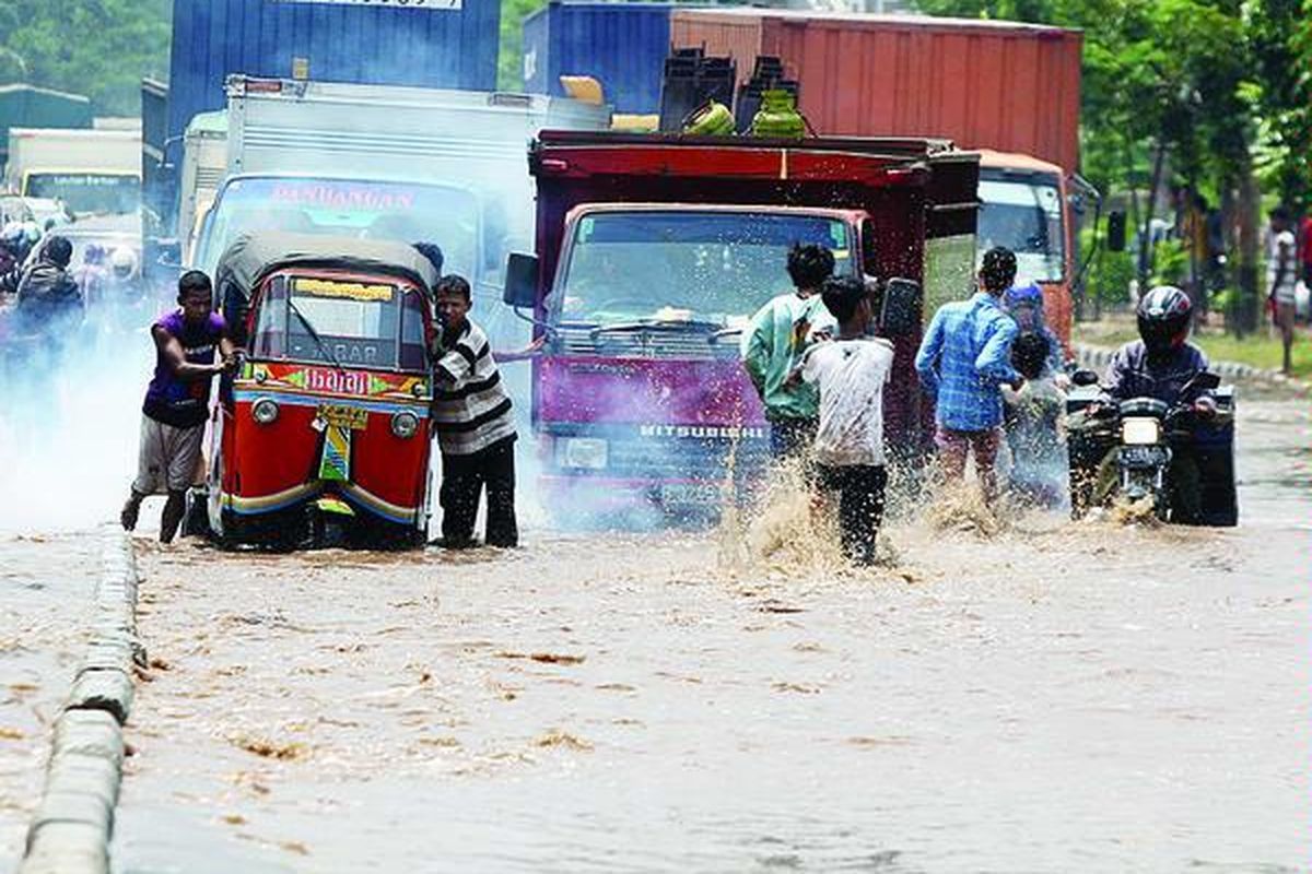 Sejumlah pemuda memanfaatkan banjir untuk mendapatkan uang dengan mendorong kendaraan yang mogok.  Banjir yang menggenangi Jalan Daan Mogot di sekitar kantor samsat, Jakarta Barat, Rabu (4/4), menyebabkan lalu lintas di kawasan tersebut macet.