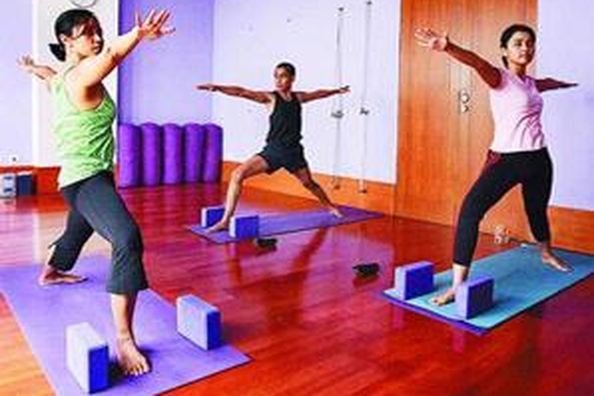 Ira, Yudhi, dan Tari (dari kiri ke kanan) melakukan olah tubuh yoga di Rumah Yoga, Kebayoran Baru, Jakarta Selatan, Jumat (19/12). 