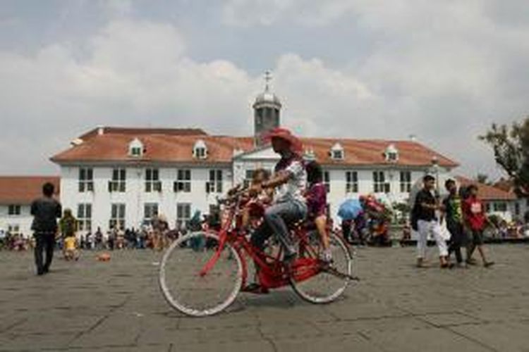 Pengunjung mengendarai sepeda sewaan di lapangan Taman Fatahillah di kawasan Kota Tua Jakarta Barat, Rabu (30/7/2014). Dua hari setelah Lebaran, kawasan Kota Tua dipenuhi warga yang mengisi masa liburan bersama keluarga.