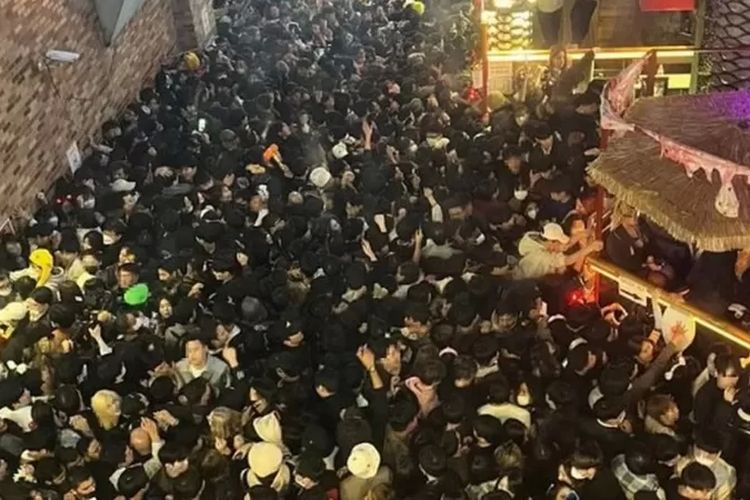 Kerumunan orang-orang yang berdesakan di gang atau lorong sempit di Distrik Itaewon, Seoul.