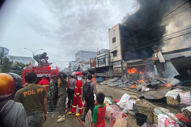 Petugas gabungan bersama warga memadamkan api kebakaran toko di Jalan Jenderal Sudirman, Kecamatan Bagan Sinembah, Kabupaten Rokan Hilir, Riau, Kamis (13/7/2023).