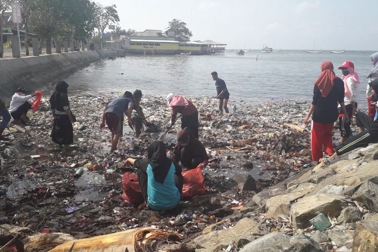 Para mahasiswa saat sedang membersihkan sampah, di pesisir dermaga pelabuhan di Pulau Bawean.