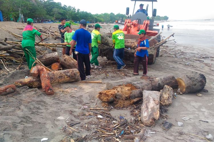 Petugas DLHK Badung membersihkan sampah kayu di pantai Kuta, Selasa (10/3/2020). 