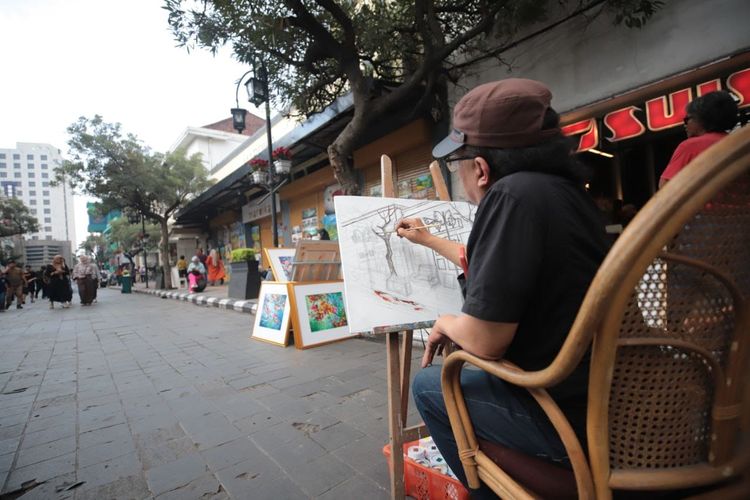 Seorang pelukis tengah menggambar keindahan Jalan Braga, Kota Bandung. 
