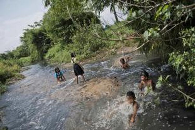 Anak-anak mandi di Sungai Cikijing yang tercemar dengan limbah industri tekstil di Rancaekek, Bandung, yang airnya mengalir ke Sungai Citarum, 22 Maret 2015.