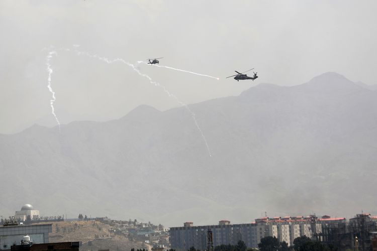 Suar umpan anti-rudal dikerahkan saat helikopter militer Black Hawk AS terbang di atas kota Kabul, Afghanistan pada Minggu (15/8/2021), dan Taliban menunggu transfer kekuasaan atas ibu kota secara damai. [AP Photo/Rahmat Gu]