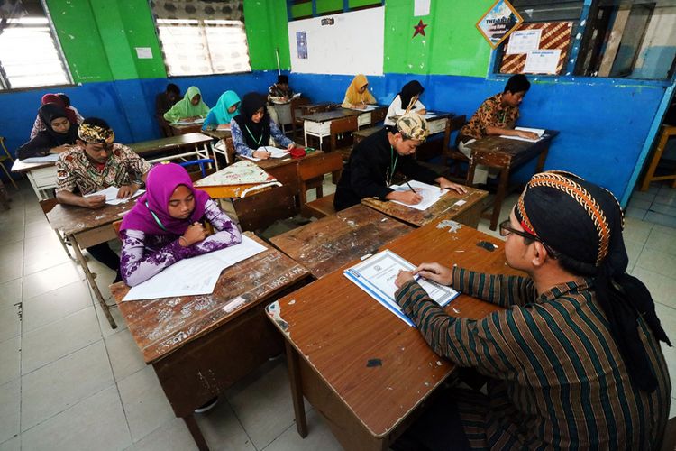 Sejumlah pelajar berbusana adat tradisional saat mengikuti Ujian Sekolah Berstandar Nasional (USBN) di SMP Muhammadiyah 11 Surabaya, Jawa Timur, Sabtu (21/4/2018). Kegiatan itu didelar dalam rangka memperingati Hari Kartini.