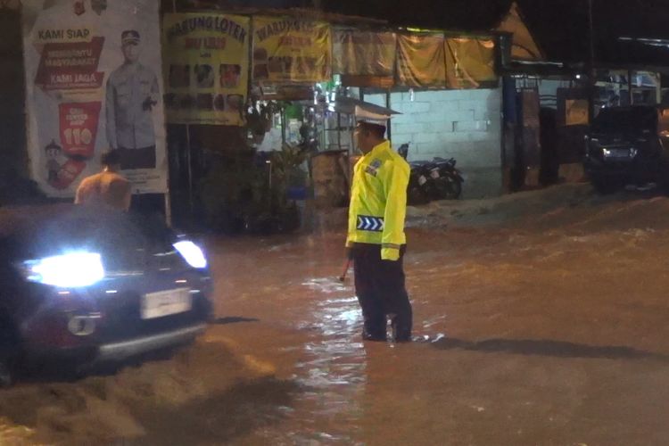 Pwtugas kepolisian tengah mengatur arus lalu lintas di Jalan Bhayangkara, yang tersendat lantaran terendam luapan sungai akibat hujan deras, selain itu beberapa Kecamatan di Kabupaten Bandung, Jawa Barat terendam banjir, Jumat (31/10/2025)
