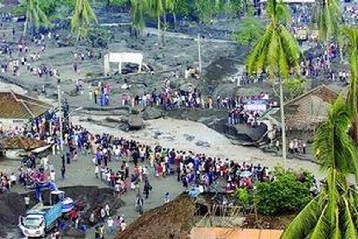 Luapan dari Kali Putih akibat banjir lahar dingin Gunung Merapi memutus jalan raya Magelang-Yogyakarta dilihat dari ketinggian di Desa Jumoyo, Kecamatan Salam, Kabupaten Magelang, Jawa Tengah, Selasa (4/1) pagi. Banjir lahar dingin terjadi pada Senin sekitar pukul 20.00. Timbunan material pasir dan batu mencapai 150 sentimeter, sementara di permukiman warga di Dusun Gempol yang tidak jauh dari Kali Putih mencapai 2 meter.