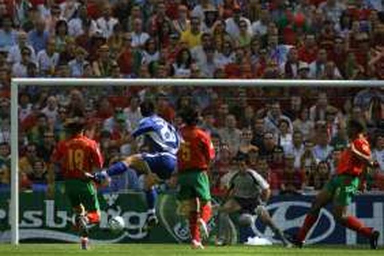 Gelandang Yunani, Georgios Karagounis (biru), mencetak gol ke gawang Portugal lewat tendangan jarak jauh pada partai pembuka Piala Eropa di Stadion Dragao, 12 Juni 2004.