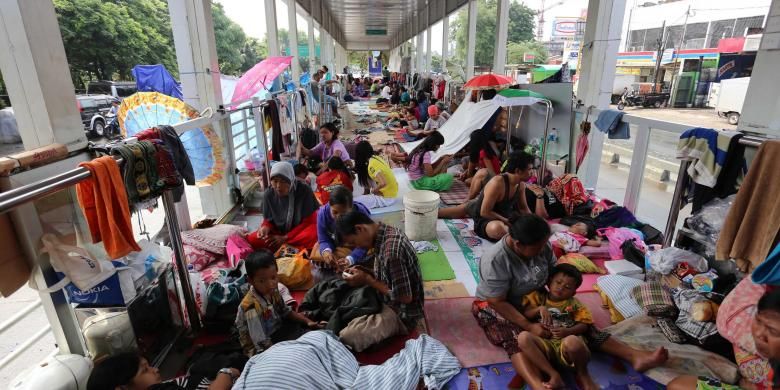 Warga mengungsi di Halte Transjakarta Jembatan Baru, Jakarta Barat, Senin (20/1/2014). Ratusan warga terpaksa mengungsi di tempat tersebut karena rumahnya terendam banjir. Banjir masih menggenangi sejumlah kawasan di Jakarta yang membuat puluhan ribu warga terdampak terpaksa mengungsi. WARTA KOTA/ANGGA BHAGYA NUGRAHA