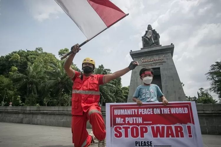 Warga melakukan aksi solidaritas dengan membawa poster hentikan perang di Manahan, Solo, Jawa Tengah, Jumat (25/2/2022).