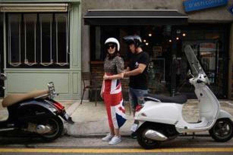 Pasangan berdiri dekat scooter mereka di kawasan kelas atas Garuso-gil, Gangnam di Seoul, 29 Agustus 2015. Seoul kini menjadi jendela baru fashion di Asia. Perusahaan-perusahaan mewah top dunia tumbuh seiring dengan budaya pop Korea Selatan yang kian tren.