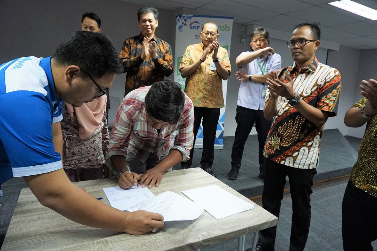 Sejumlah mitra pengemudi Grab Indonesia menandatangani akad KPR SMF-Grab, di Jakarta, Senin (2/10/2019).