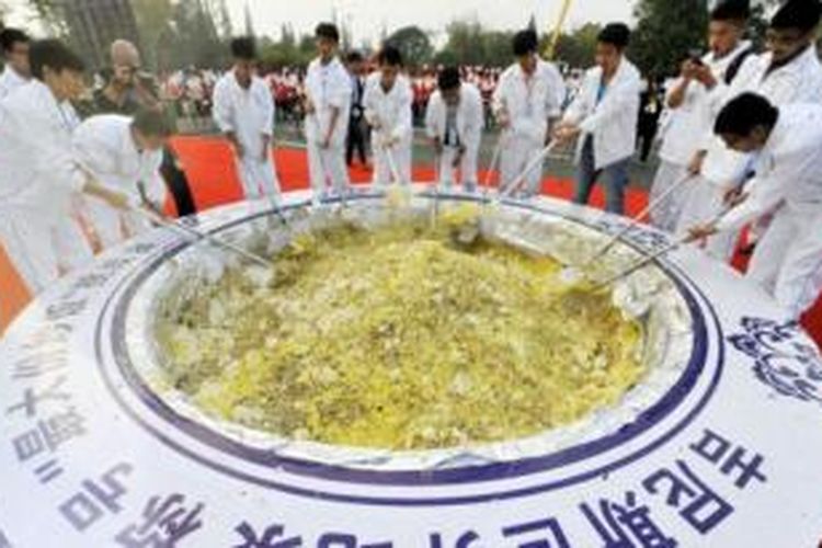 Sekitar 300 pemasak bergiliran mengaduk nasi goreng khas Yangzhou dalam upaya memecahkan rekor. 