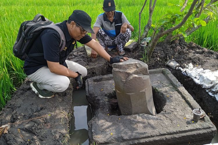Sekretaris TACB Kabupaten Nganjuk, Sukadi, saat memeriksa Lingga dan Yoni di area persawahan Dusun Tanjungkalang, Desa Tanjungkalang, Kecamatan Ngronggot, Kabupaten Nganjuk, Jawa Timur, yang rusak diduga gara-gara aktivitas ekskavasi ilegal, Rabu (28/5/2025)