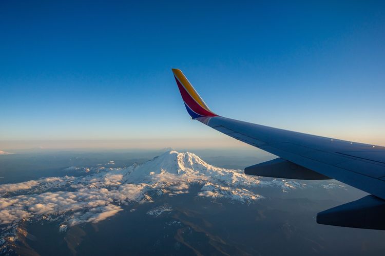 Pemandangan sayap dan pegunungan dari jendela pesawat