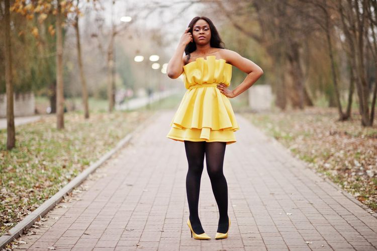 Ilustrasi perempuan berkulit gelap pakai baju kuning