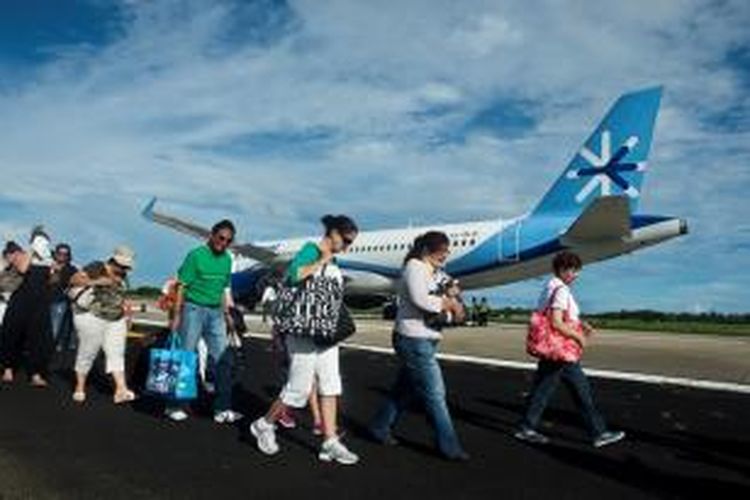 Para wisatawan terpaksa berjalan di landas pacu bandara Acapulco, Meksiko untuk menanti penerbangan yang akan membawa mereka keluar dari kota wisata tersebut. Setidaknya 40.000 wisatawan terjebak di Acapulco setelah jalur transportasi terputus pasca-hantaman topan Ingrid dan Manuel.