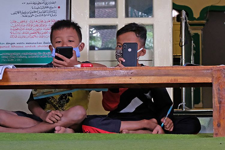Sejumlah siswa belajar secara daring di serambi masjid At Taqwa Dusun XIV, Borobudur, Magelang, Jawa Tengah, Rabu (29/7/2020). Pihak takmir masjid setempat menyediakan layanan internet gratis khusus untuk pembelajaran daring guna meringankan beban ekonomi warga dalam belanja paket data sekaligus untuk memakmurkan masjid.