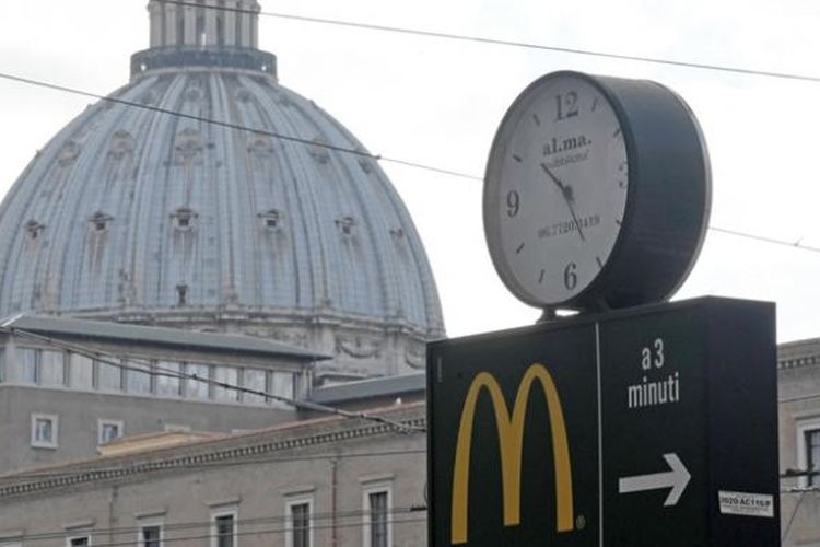 Lambang restoran cepat saji McDonalds dengan latar belakang kubah Basilika Santo Petrus, Vatikan.
