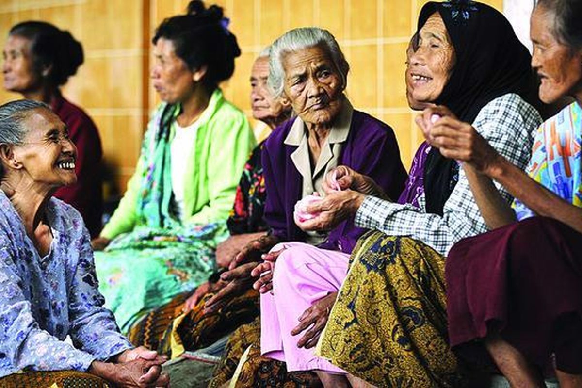 Sejumlah pengungsi lanjut usia bercengkerama sambil memakan kerupuk yang dibagikan sukarelawan di barak pengungsian korban letusan Gunung Merapi di Desa Dompol, Kecamatan Kemalang, Klaten, Jawa Tengah, Rabu (3/11). Rasa kebersamaan pengungsi semakin kuat dengan saling berbagi makanan dan cerita selama hidup di tempat pengungsian.