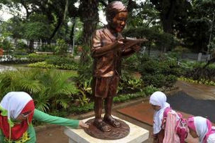 Anak-anak  melihat patung KH Abdurrahman Wahid atau Gus Dur saat masih kecil di Taman Amir Hamzah, Menteng, Jakarta Pusat, Sabtu (25/4/2015). Patung berbahan perunggu  tersebut diharapkan dapat memberikan inspirasi kepada generasi muda atas pemikiran dan teladan Gus Dur untuk bangsa Indonesia.
  