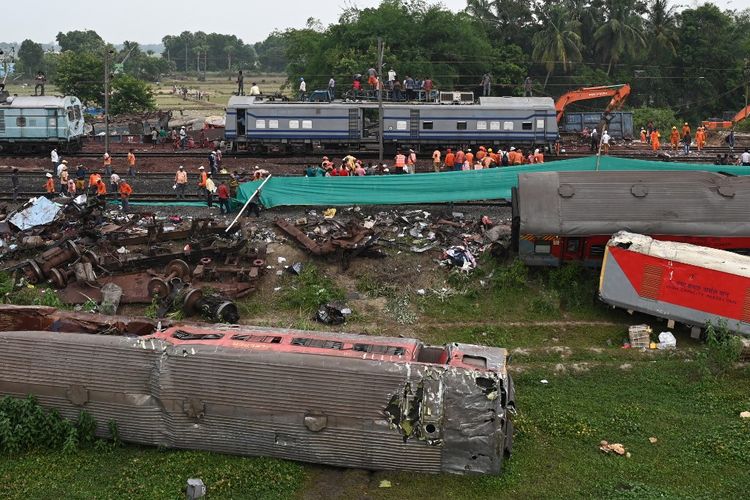 Pekerja kereta membantu memulihkan layanan di lokasi kecelakaan tabrakan tiga kereta di dekat Balasore, sekitar 200 km dari ibu kota negara bagian Bhubaneswar di negara bagian timur Odisha, pada 4 Juni 2023. Tim kereta api bekerja tanpa henti pada tanggal 4 Juni memulihkan jalur setelah kecelakaan kereta api paling mematikan di India dalam beberapa dekade terakhir.