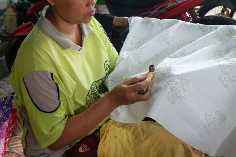 Proses pembuatan batik tulis oleh seorang pengrajin di Kampung Batik Laweyan, Solo.