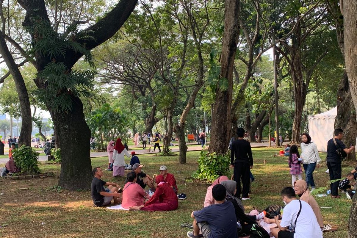 Sejumlah masyarakat tampak berwisata sambil berpiknik di area taman Monas, Jakarta Pusat, Minggu (19/6/2022).