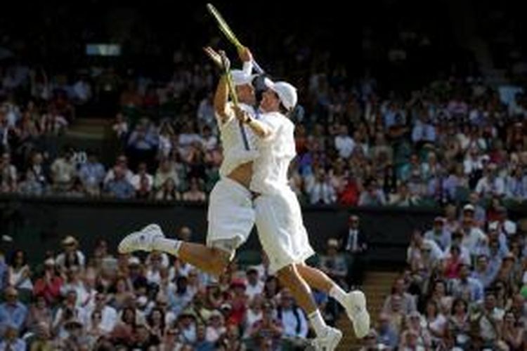 Petenis ganda Amerika Serikat, Bob Bryan dan Mike Bryan melakukan chest bump untuk merayakan kemenangan mereka atas Ivan Dodig (Kroasia) dan Marcelo Melo (Brasil), pada laga final turnamen Grand Slam Wimbledon, Sabtu (6/7/2013).