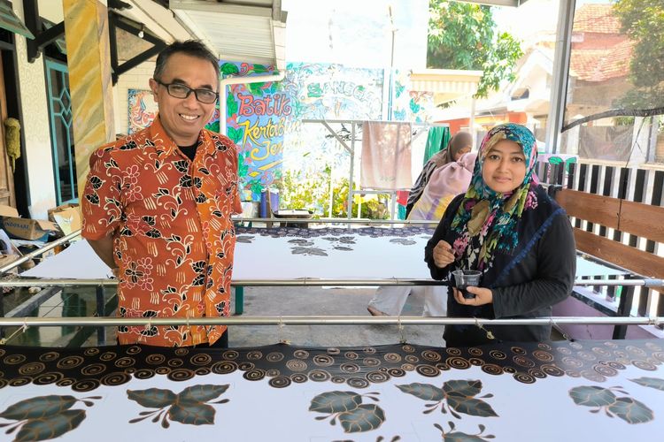 Musbahudin mengawasi adik iparnya, Siti Muyasaroh yang turut menjadi pegawainya di Batik Kertabumi Jember Kelurahan Jember Kidul, Kecamatan Kaliwates, Kabupaten Jember, Kamis (2/10/2025).