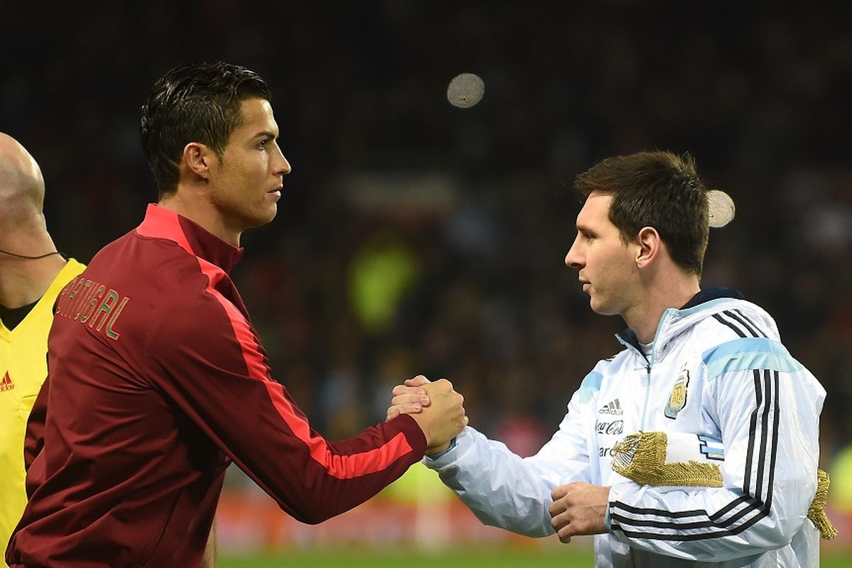 Striker Argentina Lionel Messi (kanan) berjabat tangan dengan striker Portugal Cristiano Ronaldo (kiri) menjelang pertandingan persahabatan internasional antara Argentina dan Portugal di Old Trafford di Manchester pada 18 November 2014.