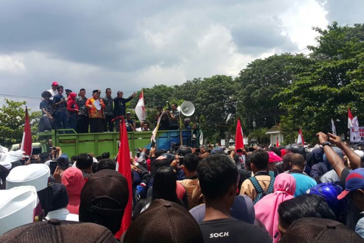  BERORASI--Bupati Sukoharjo, Wardoyo Wijaya berorasi memberikan penjelasan kepada ribuan pengunjuk rasa yang menuntut PT RUM ditutup permanen di halaman Pemkab Sukoharjo, Kamis (22/2/2018).
